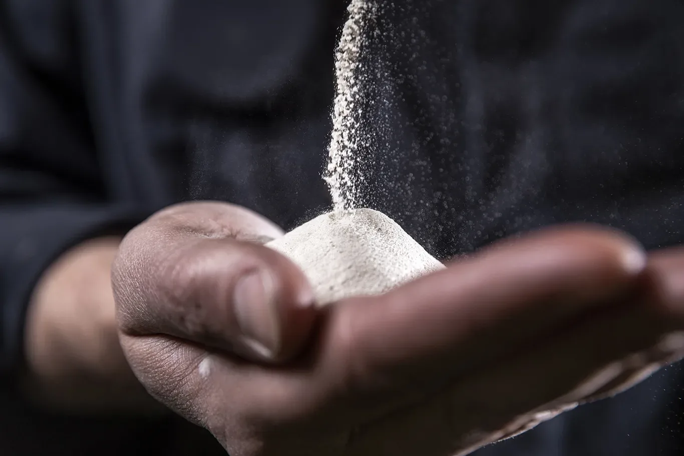 Hand with white powdery substance.