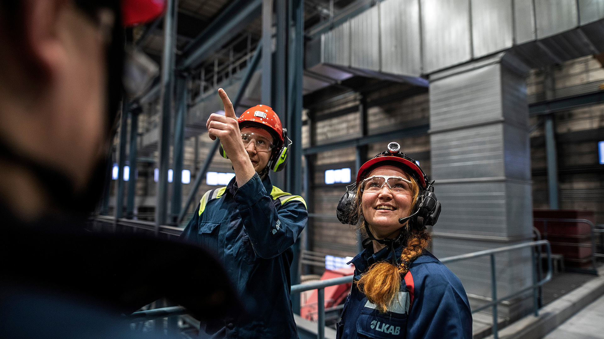 Two people in work clothes in factory environment