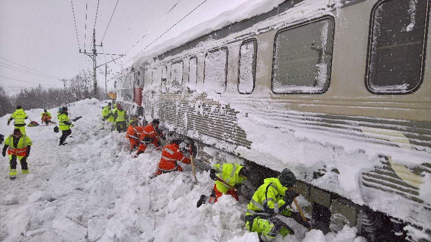 LKAb-anställda handskottar fram persontåg som sitter fast i snön på Malmbanan.