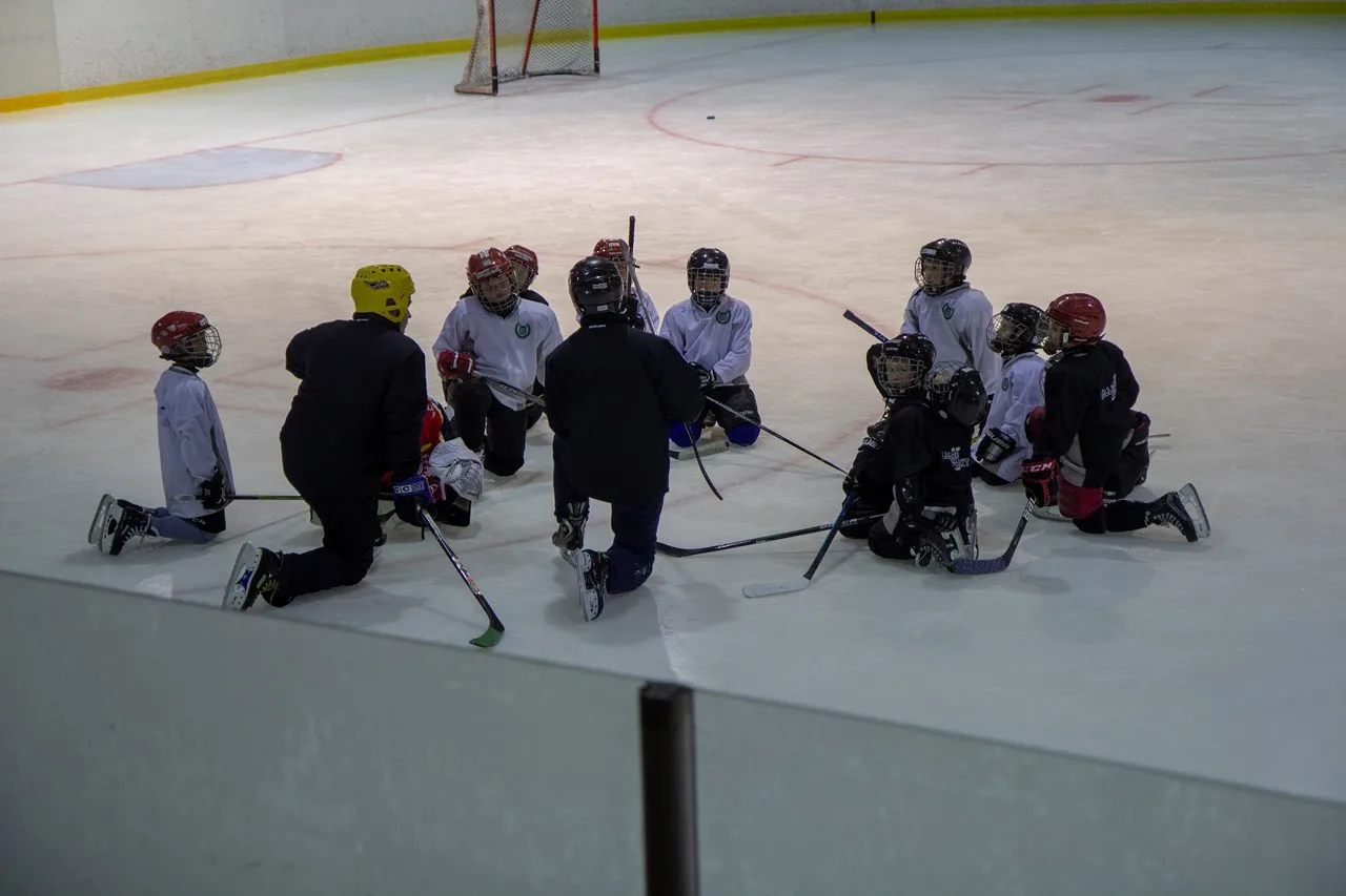 Grupp hockeyspelare i en cirkel på isen.
