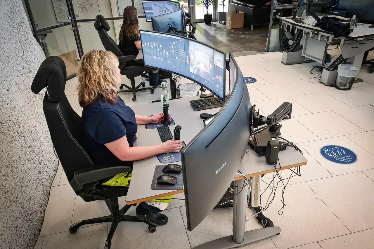 Women in control room with big screens.