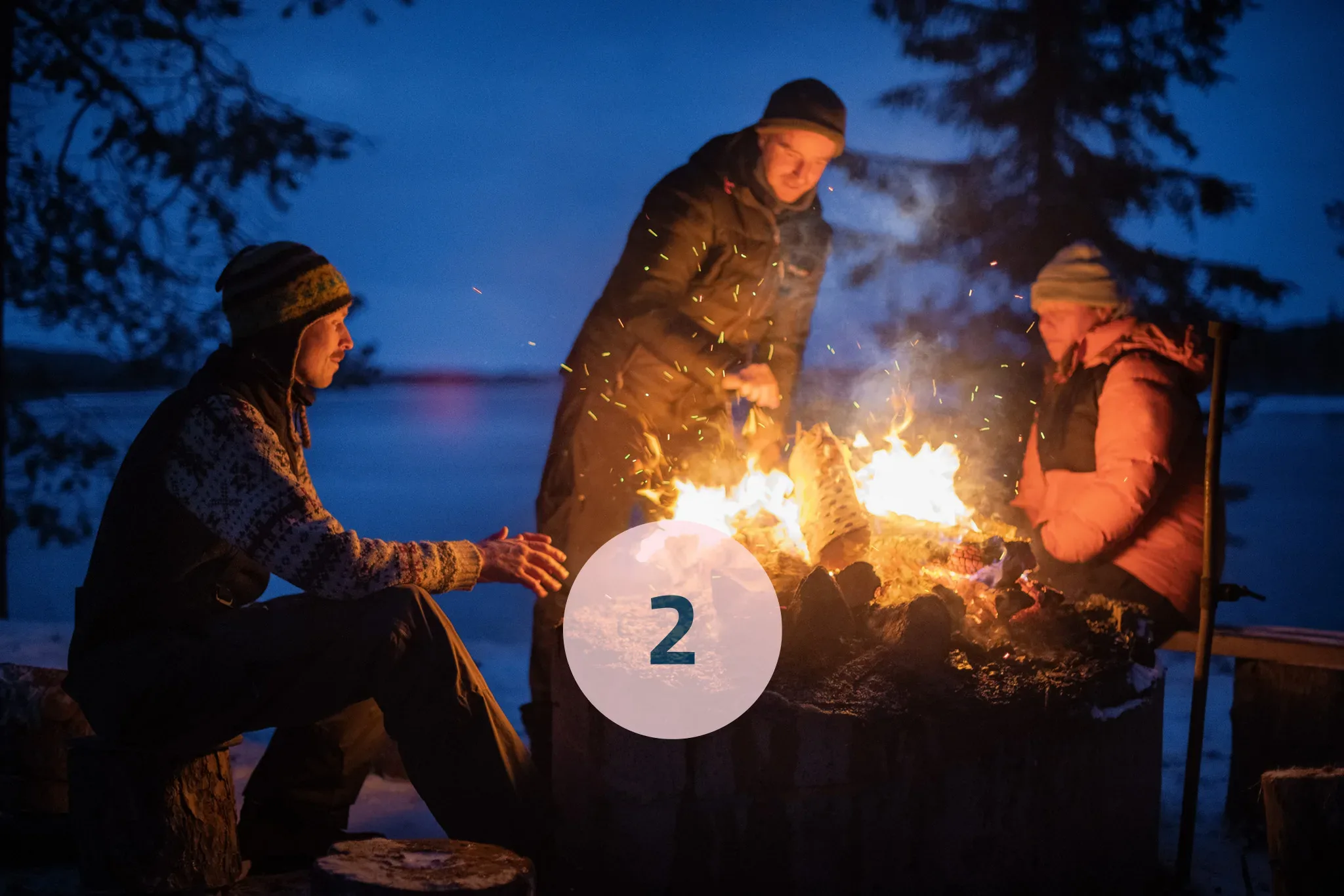 Group of people sitting around a fire. 