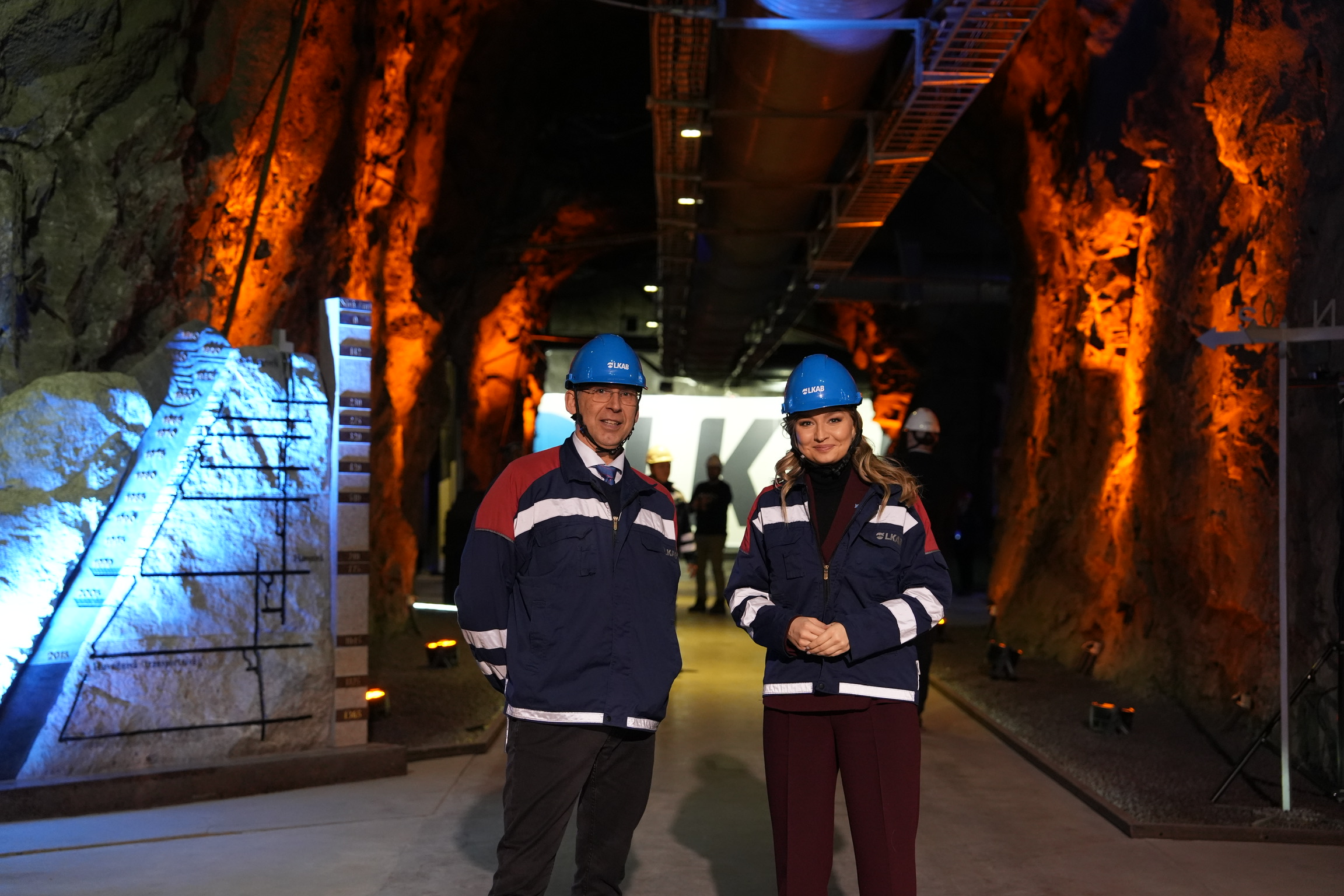 Man and woman i mining helmets in underground environment. 