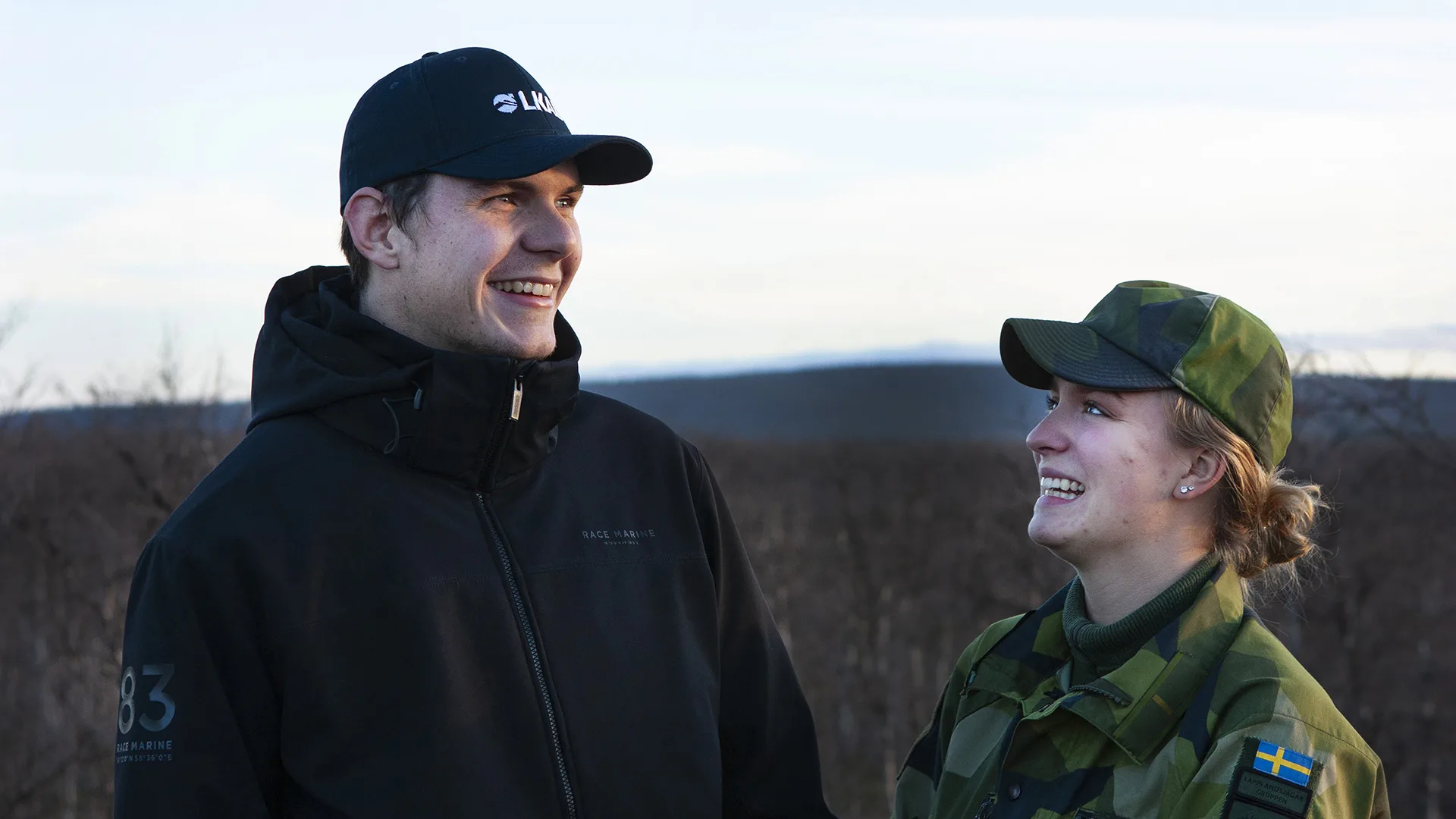 Två personer utomhus, varav en i försvarsmaktens uniform.