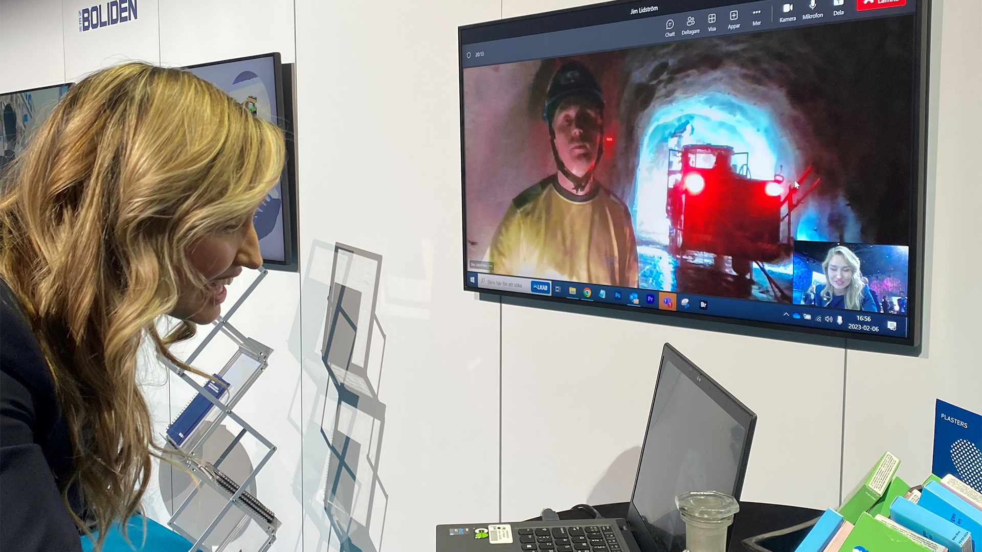Kvinna tittar i datorskärm, med monitor i bakgrunden