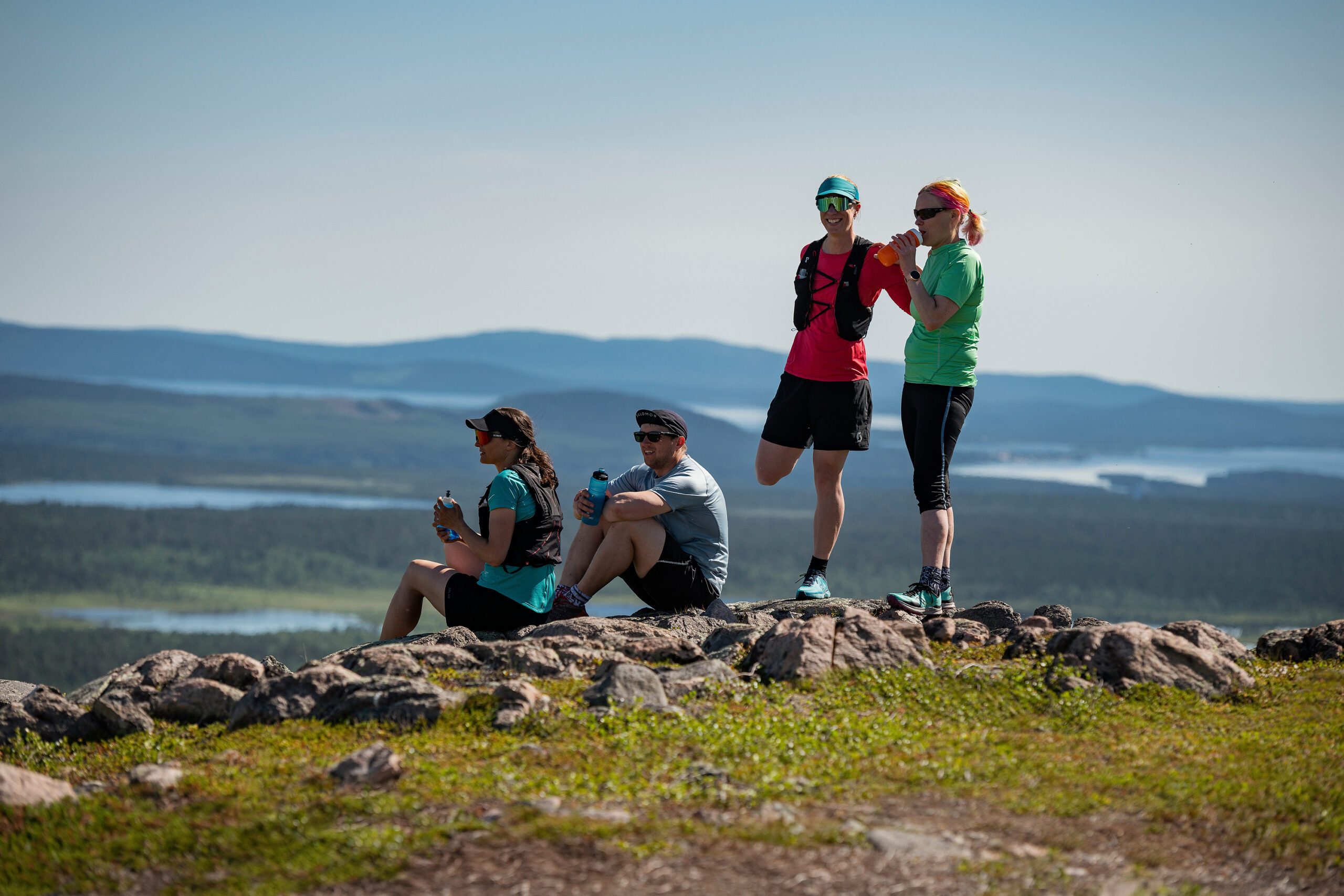 Four people in training clothes on mountain top.