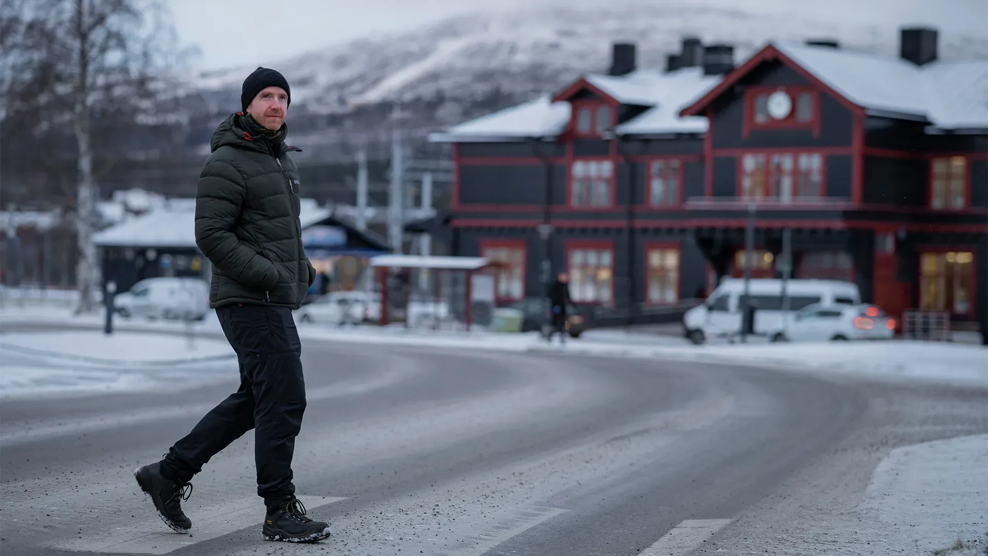 Man promenerar över gatan i vinterlandskap