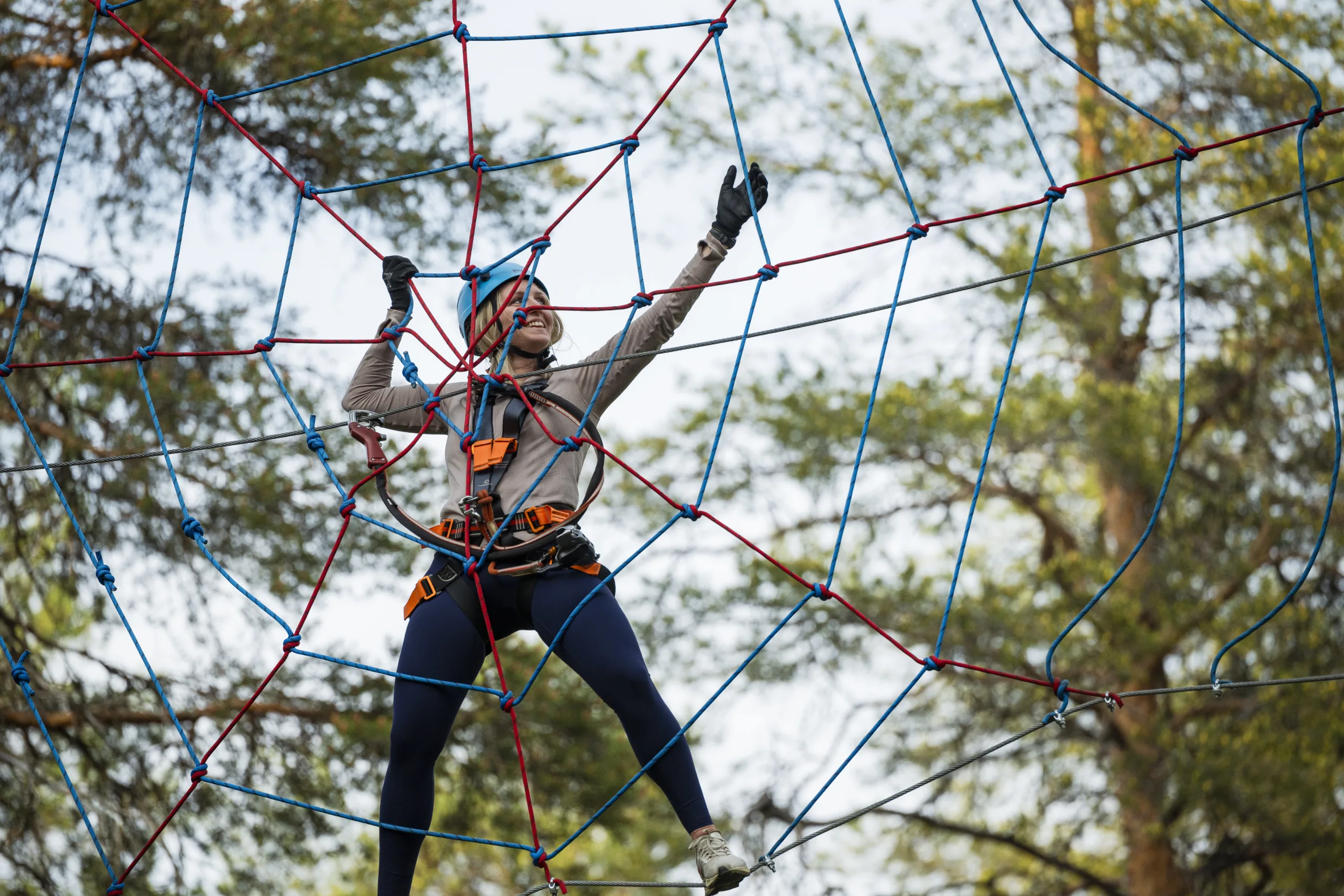 Woman climbing high ropes