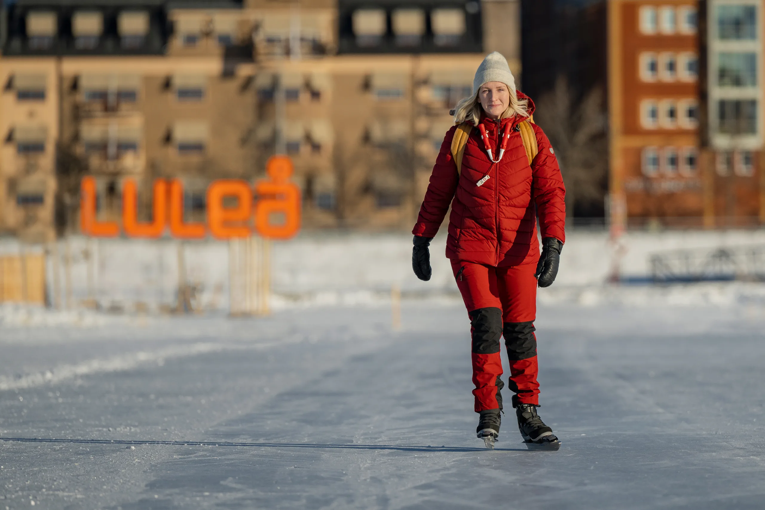 Kvinna åker skridskor, med Luleå-skylt i bakgrunden