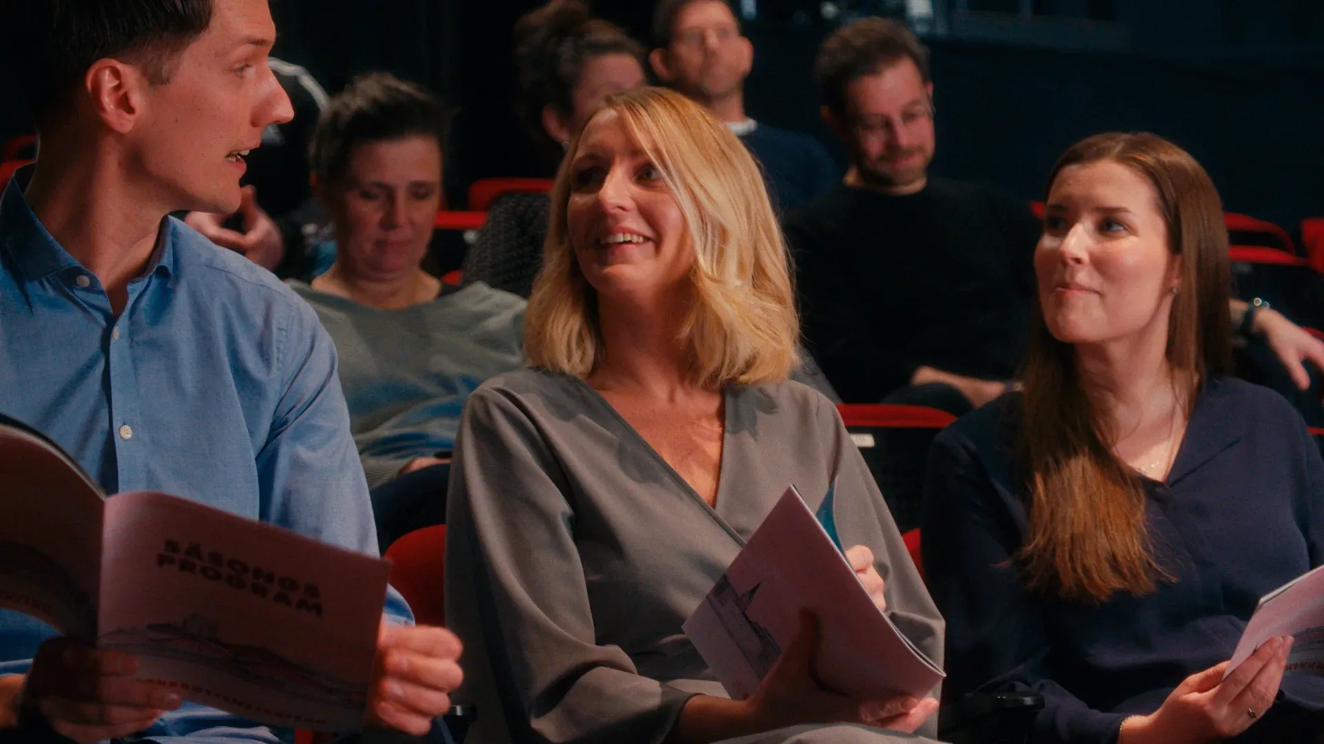 Three people talking in a movie theatre