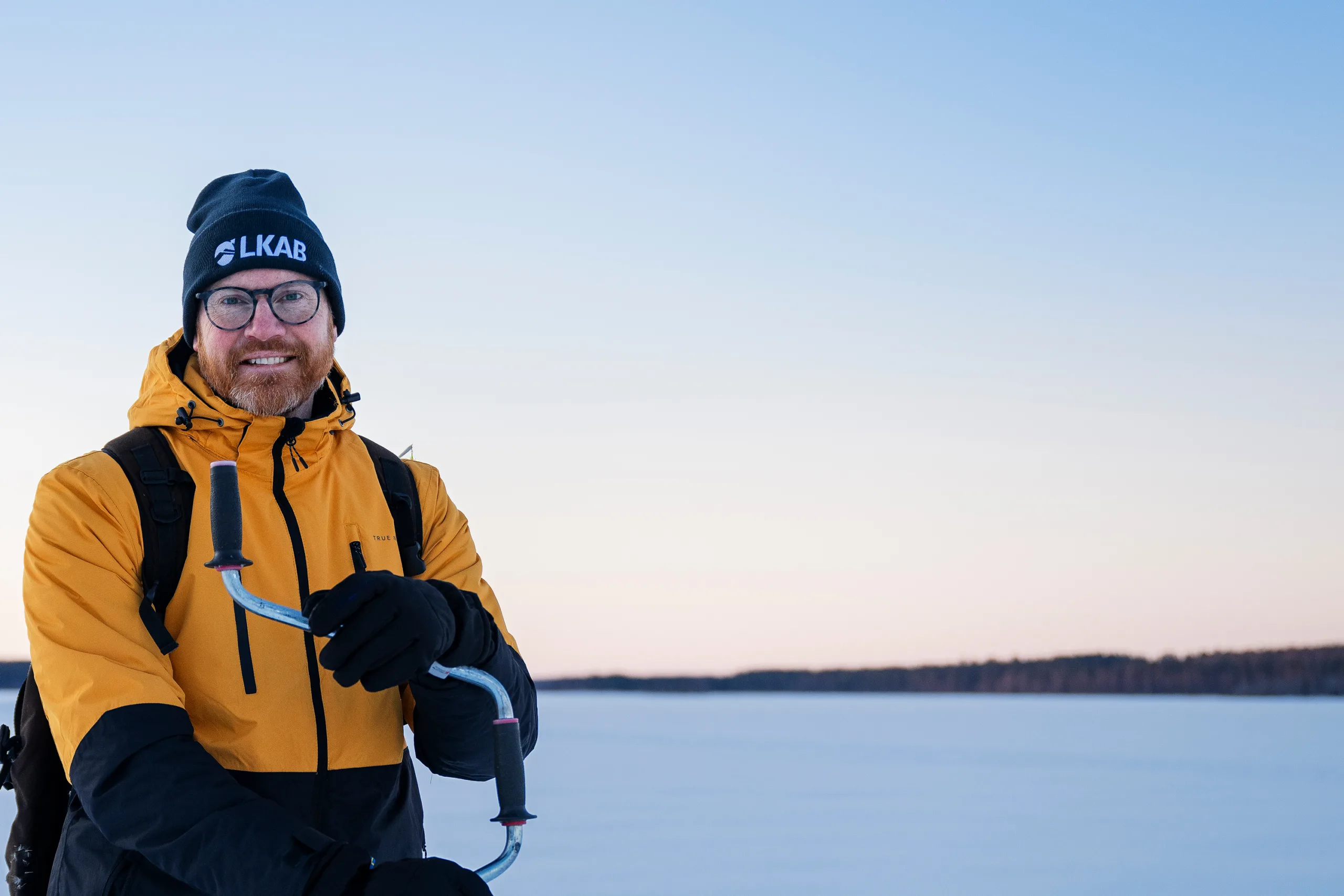Man in winter clothes and LKAB-hat on sea ice