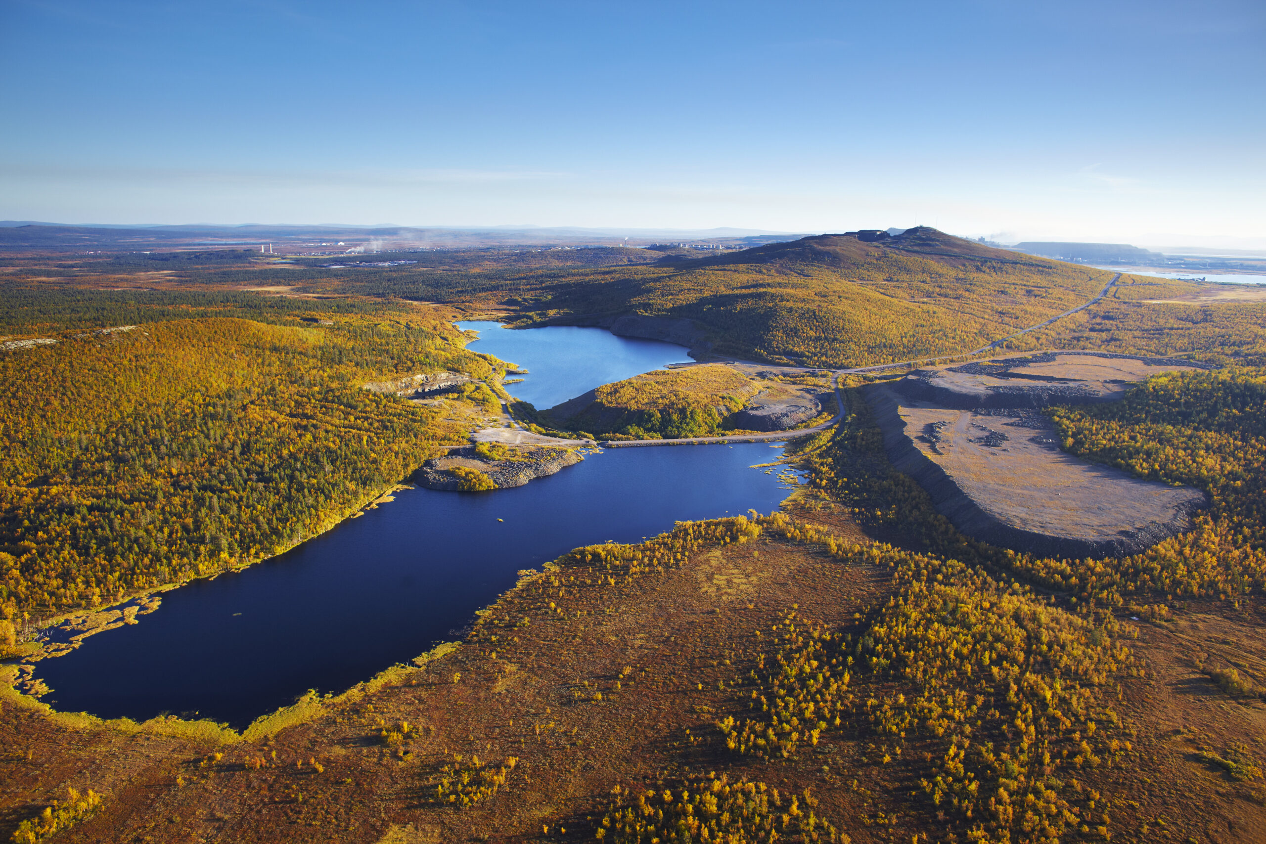 Aerial view of lake, surrounded by swamps, mountains and forests. 