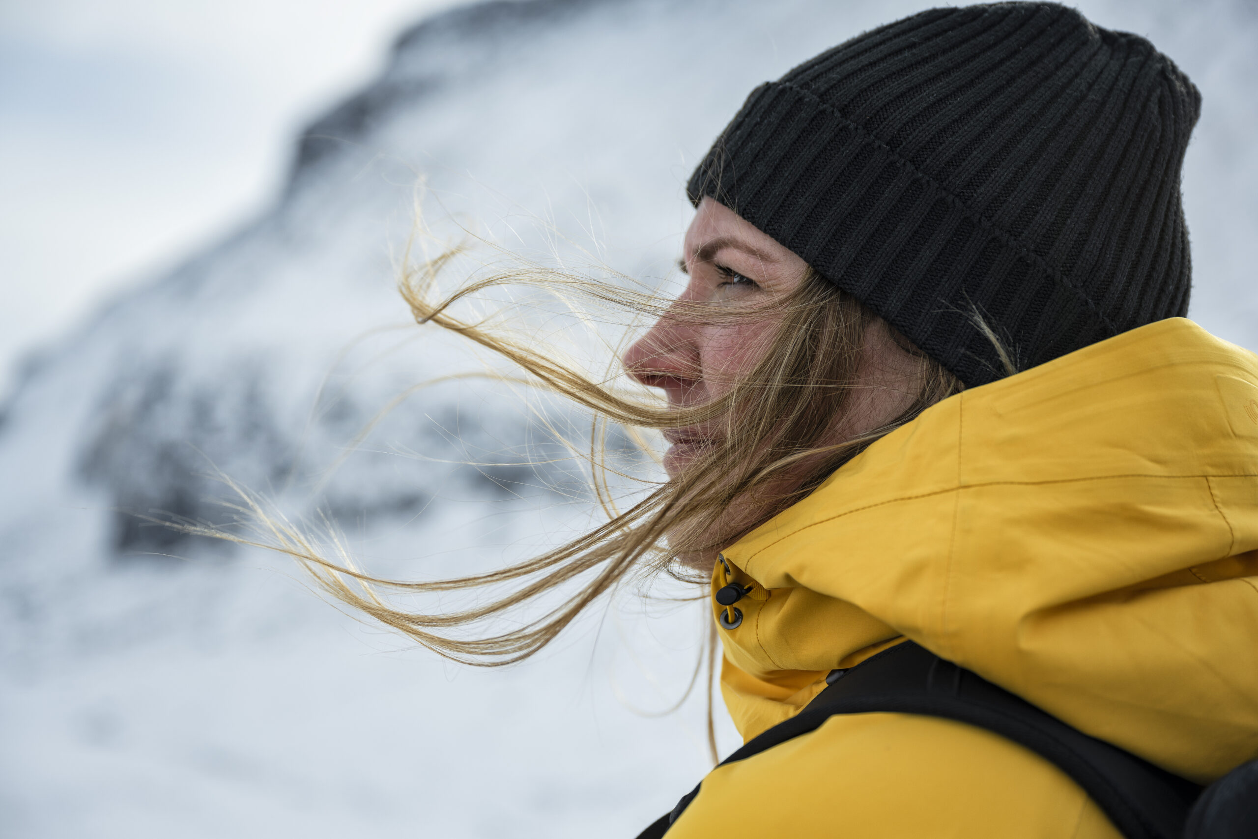 Kvinna i gul vinterjacka i snölandskap
