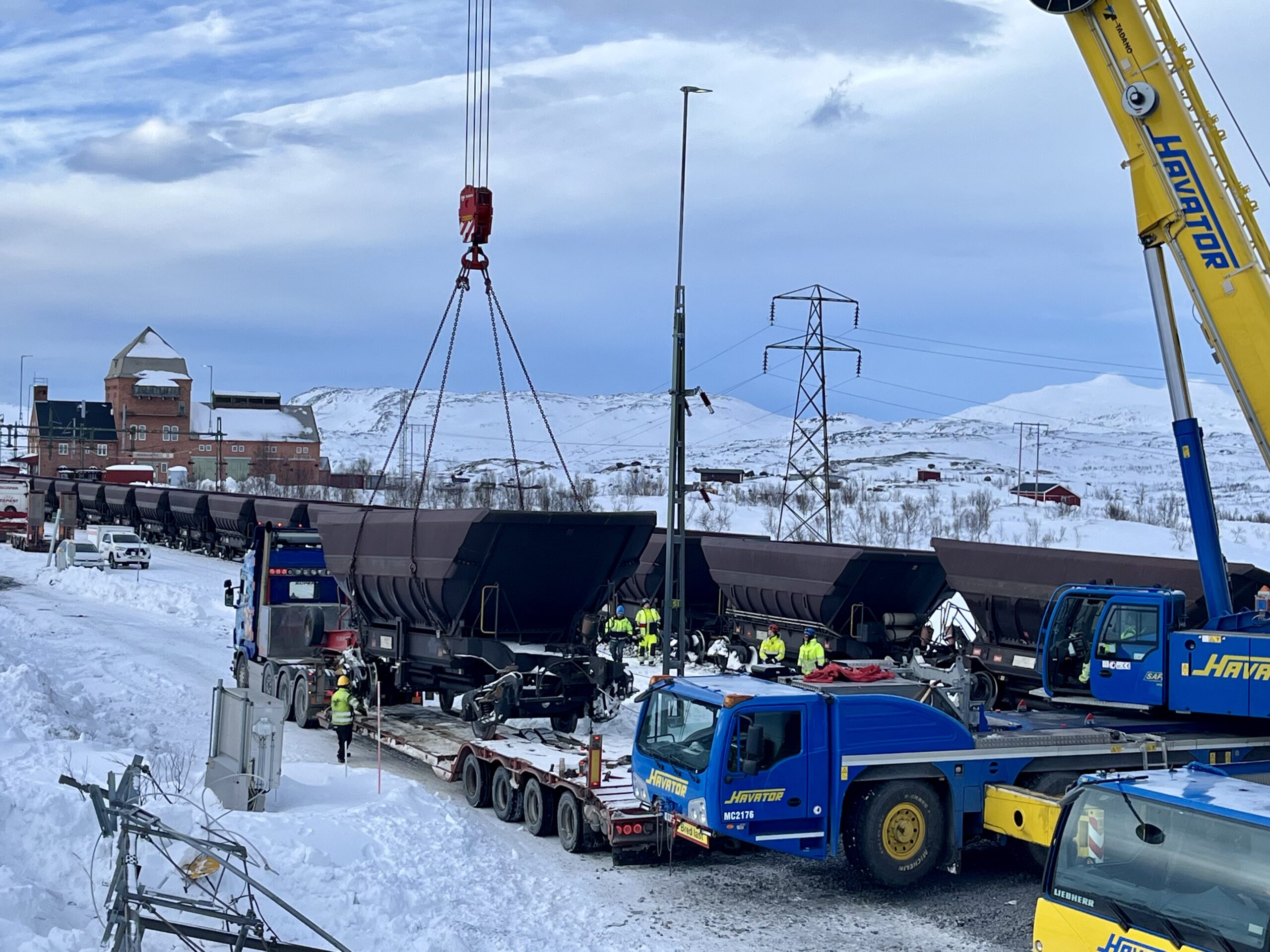 Kran lyfter malmtåg på lastbil