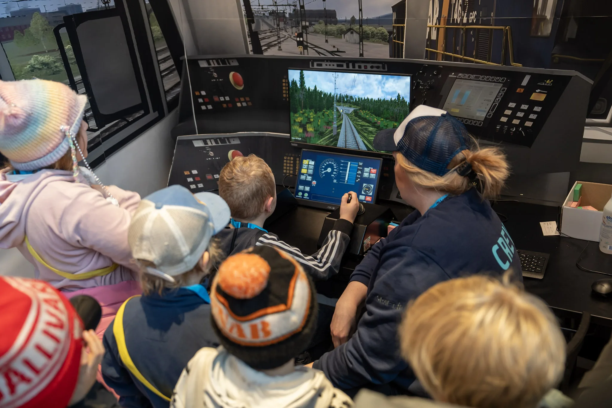 En grupp barn vid en tågsimulator.
