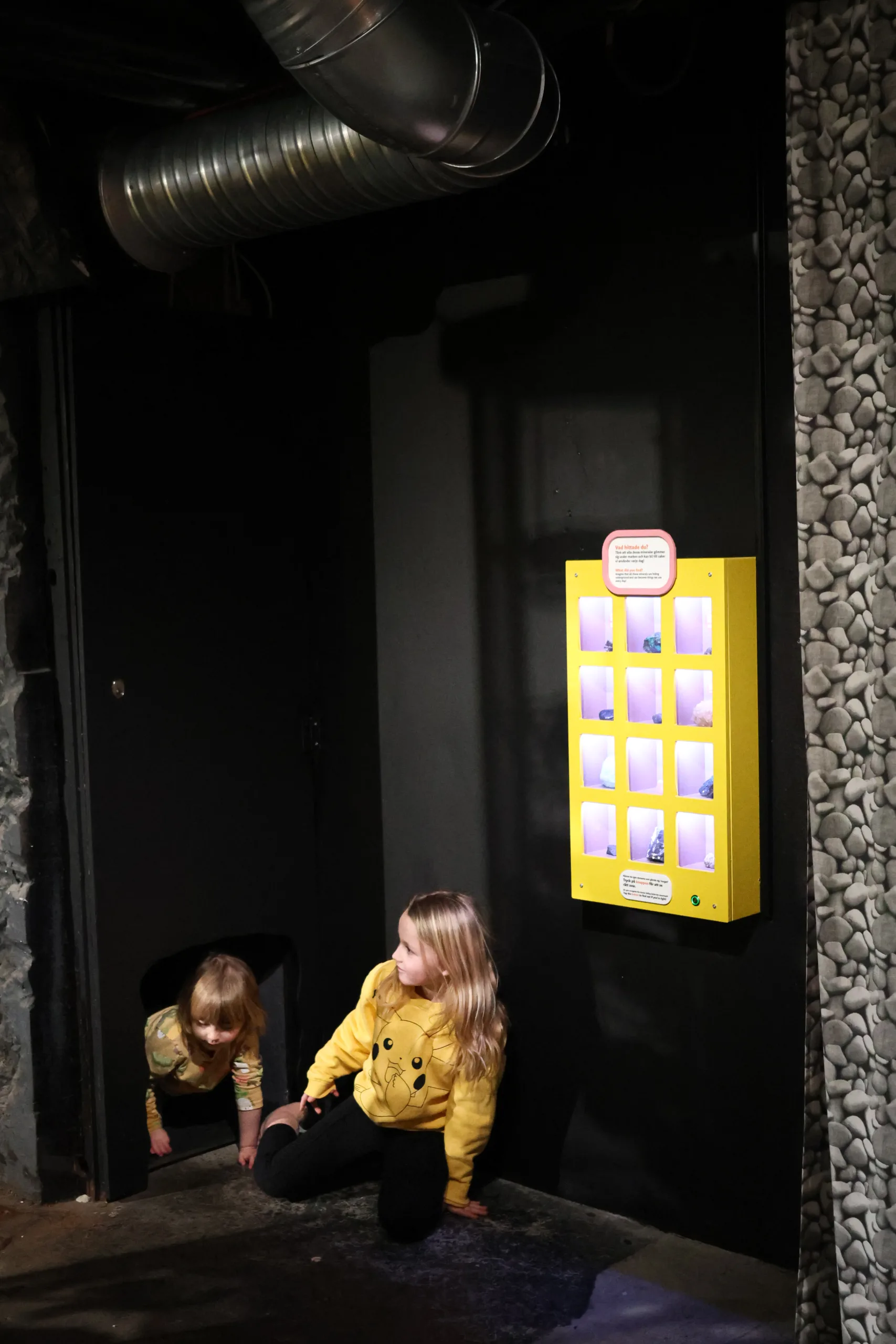 Två barn som kryper på golvet i gruvutställningen